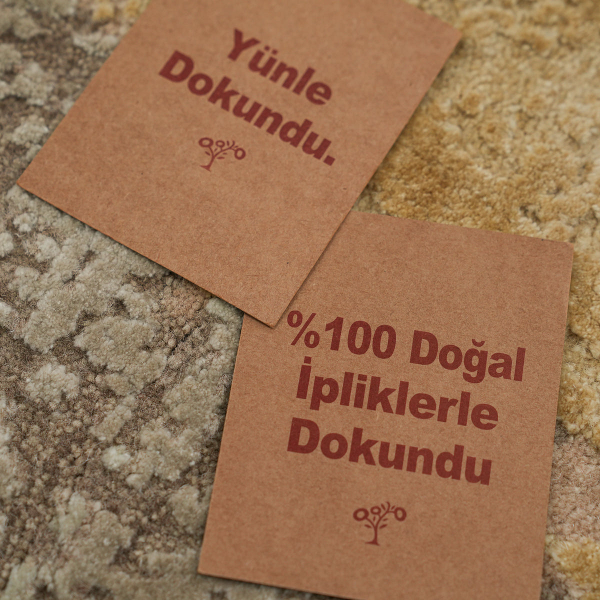 Aren Serisi hardal vurgulu vizon soyut desenli halı — hav üstüne bırakılmış iki kraft etiket