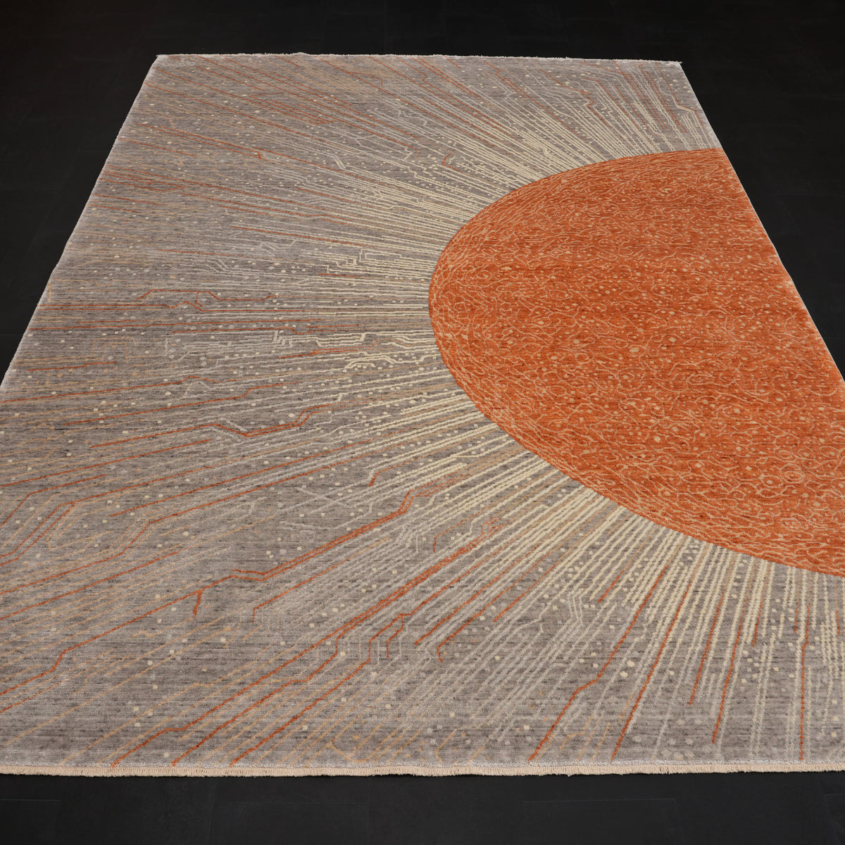 Günyolu Series orange-half-disc gray abstract rug — full length at an angle from above on a dark ground, the orange disc at the right edge
