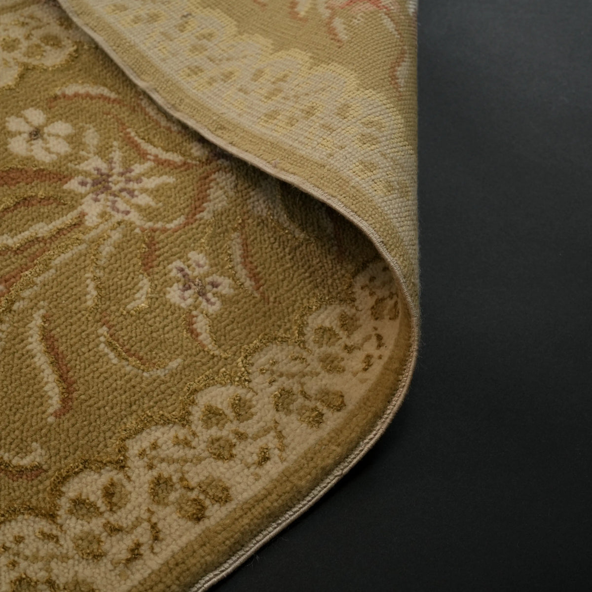 Harem Series mustard-border beige Oushak-pattern rug — the pile curling over; the border's white flowers across the fold