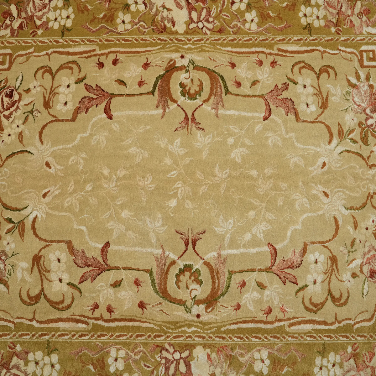 Harem Series medallion cream Oushak-pattern rug — macro of the field; the curling vines of the inner frame and the rosettes at its corners