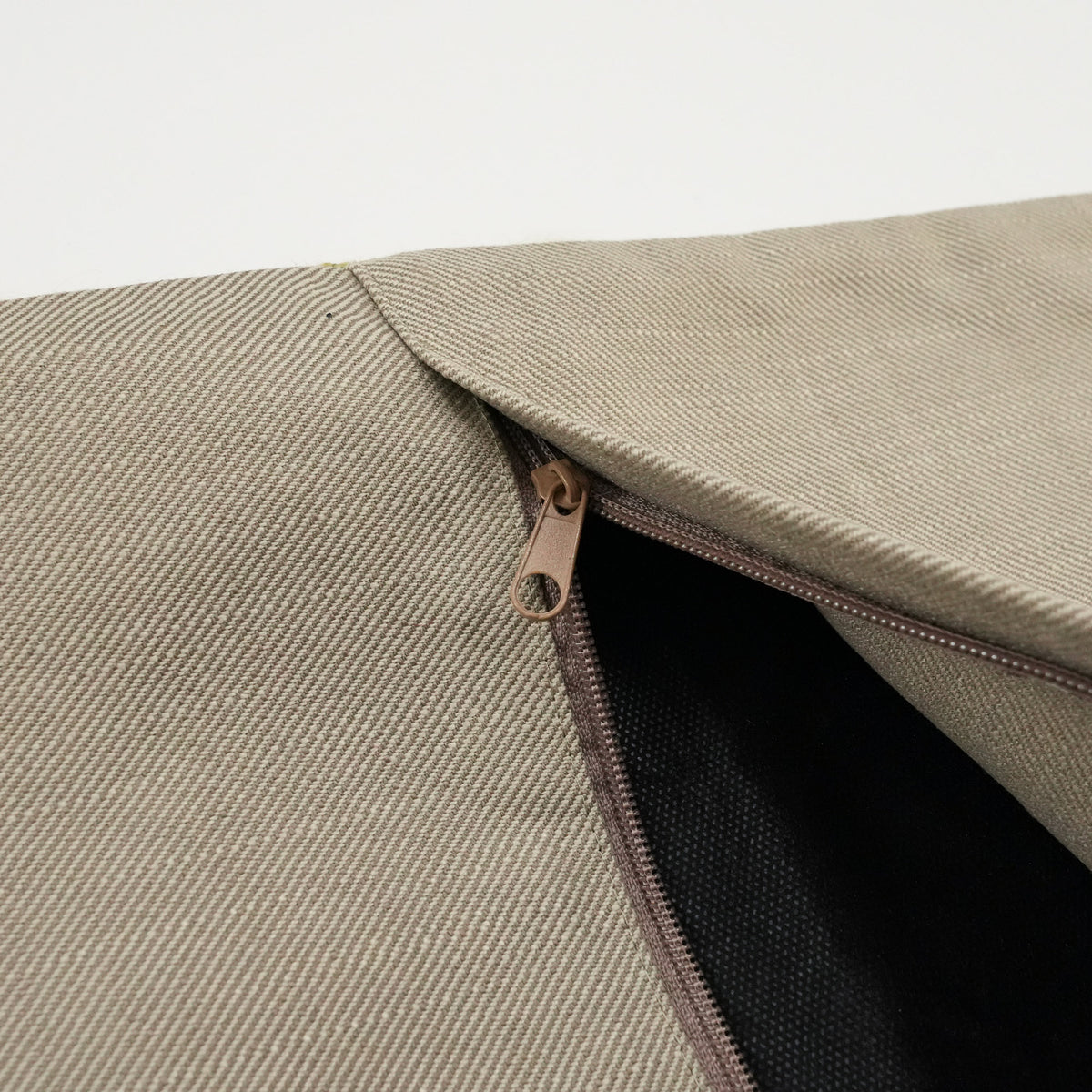 plain green cushion cover — open zipper on the beige back, dark lining inside