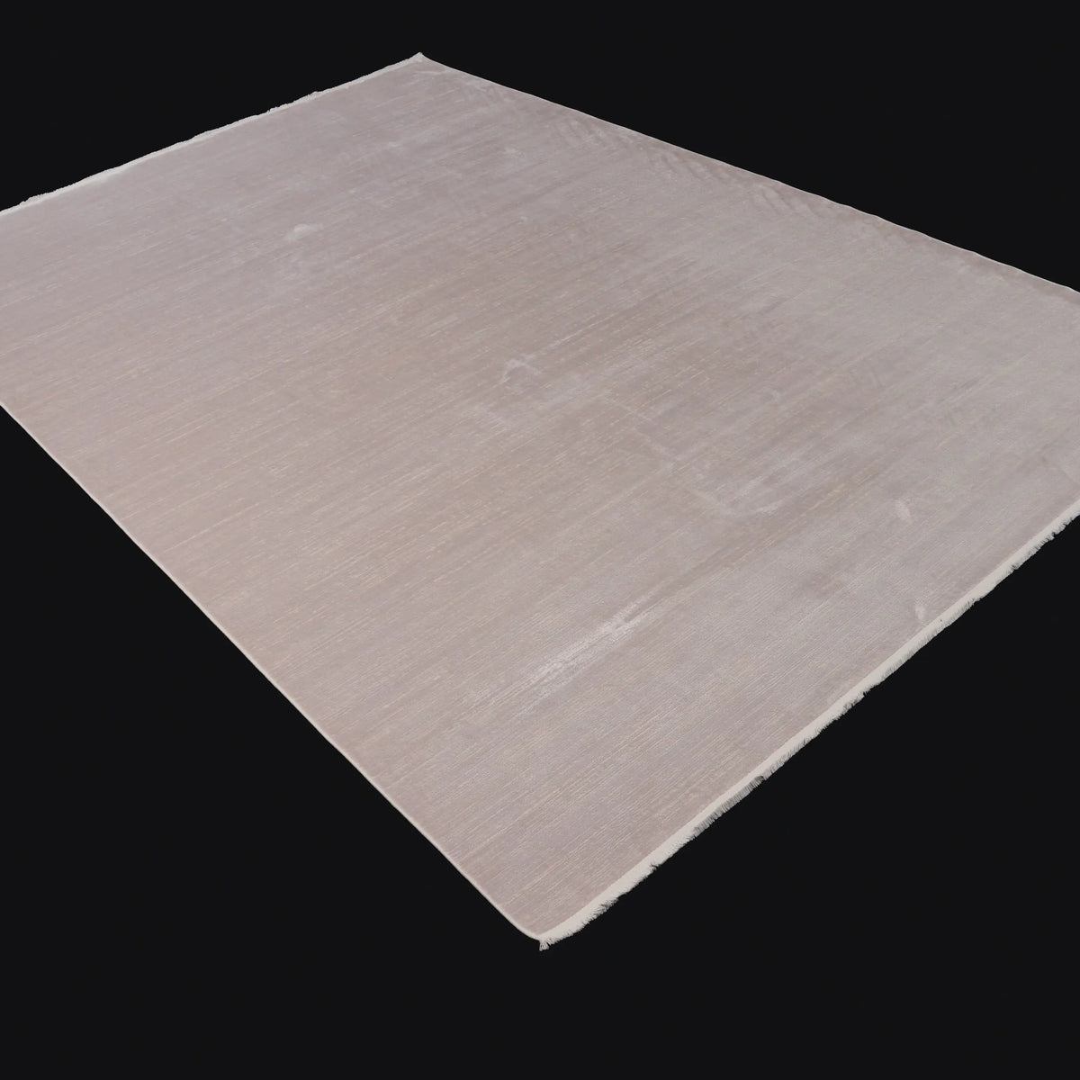 Odak white plain rug — the whole rug at an angle on a dark backdrop; the surface turning matte and lustrous with the viewing angle