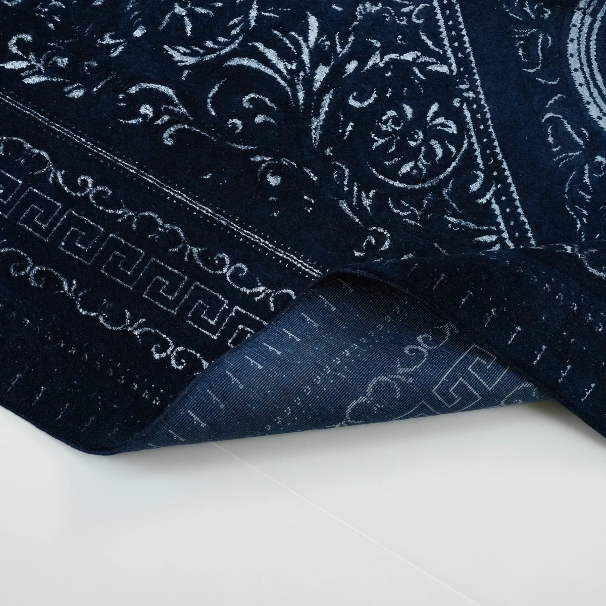 Versace Series navy medallion rug — the edge curled; the pattern bending along the fold