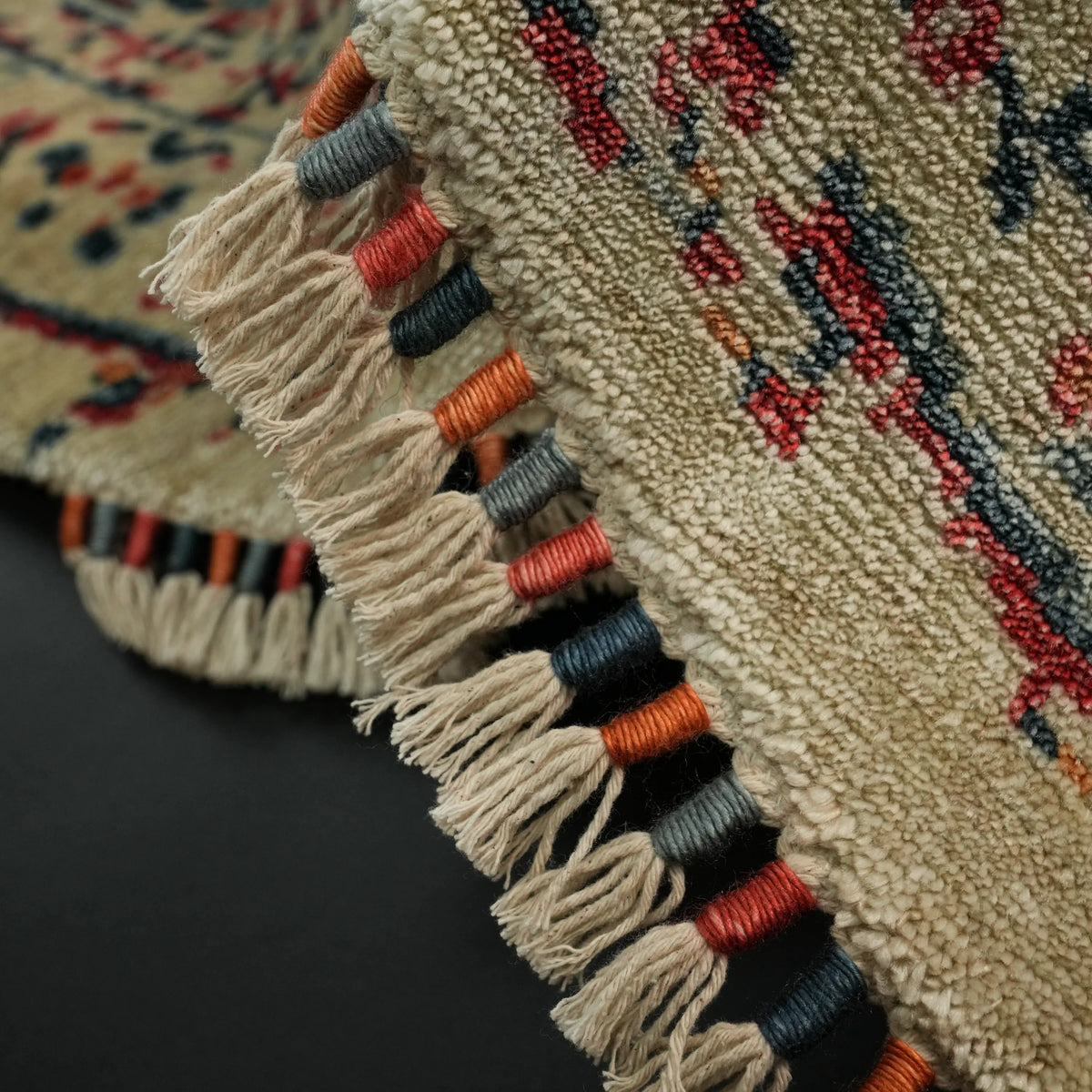 Zade Serisi mavi vintage desenli yuvarlak halı — kenar kıvrılmış; turuncu, lacivert ve kırmızı sarımlı saçaklar ve havın dokusu
