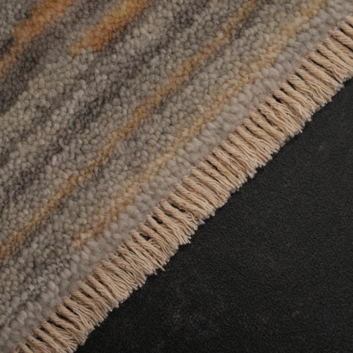 Zima Series fine orange-crackle gray abstract rug — macro on the fringe row, a section of pile showing