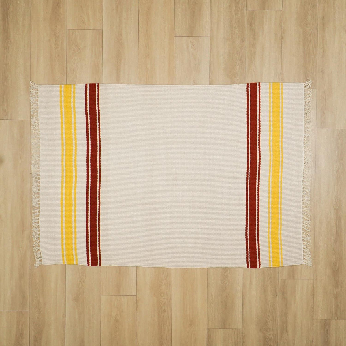 krem çizgi desenli kilim — ahşap zeminde cepheden tamamı; iki yanda dikey bordo ve sarı şeritler