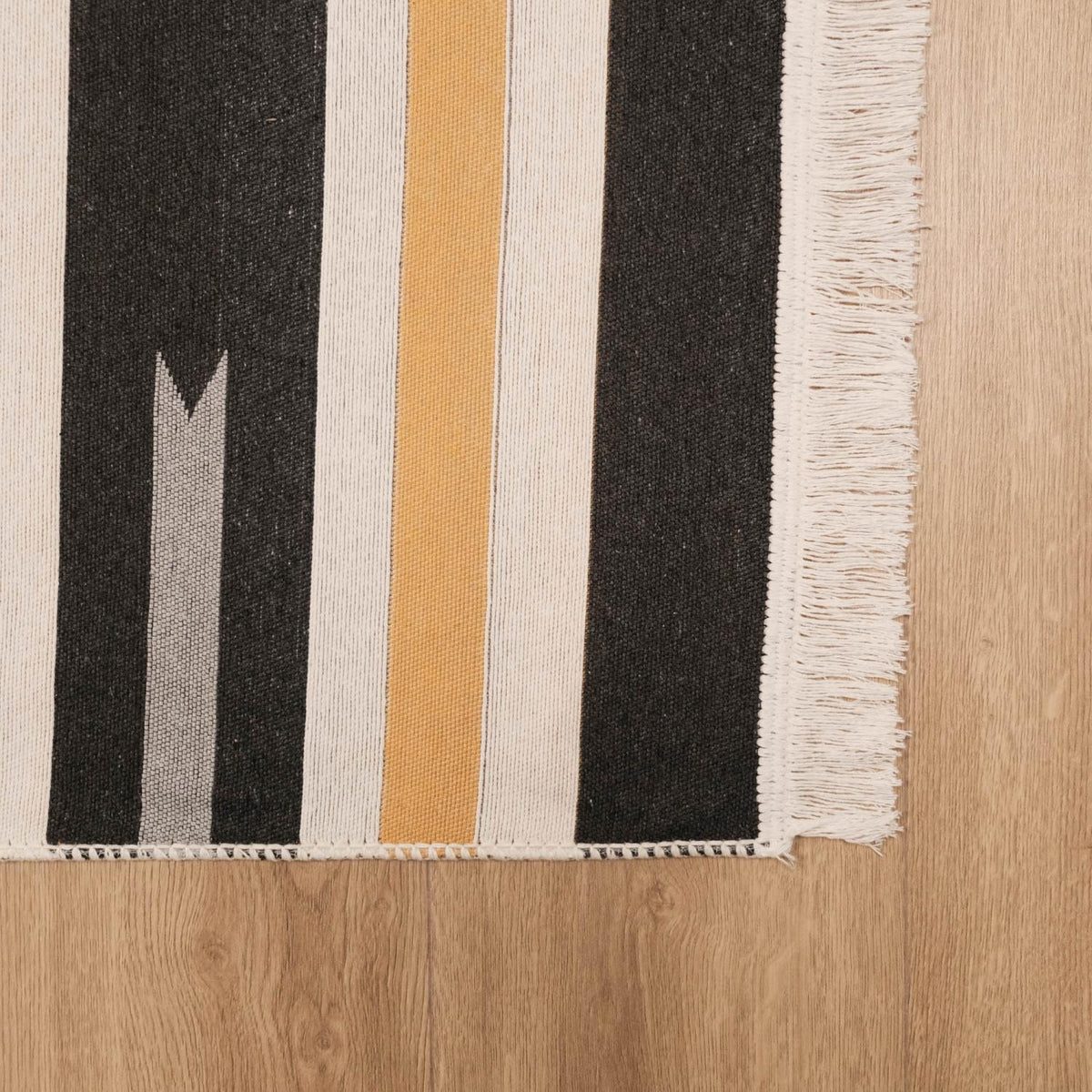 Kehribar Series gray striped kilim — corner area, edge band and fringe angled on parquet