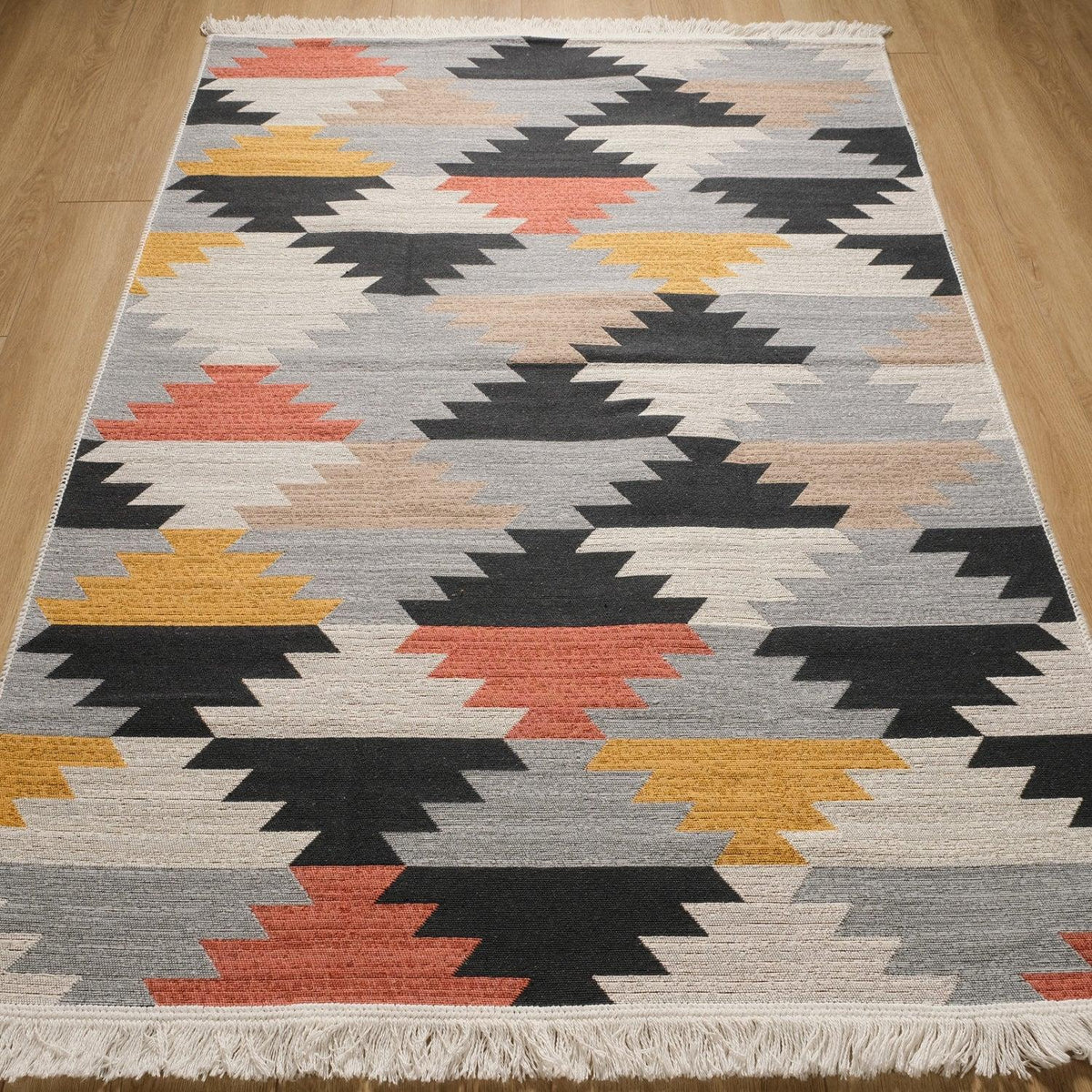 Kehribar Series multicolor geometric kilim — full length on parquet, rows of stepped diamonds, fringe below