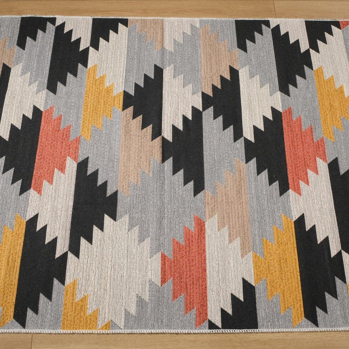 Kehribar Series multicolor geometric kilim — close framing of the patterned area, coral and mustard steps
