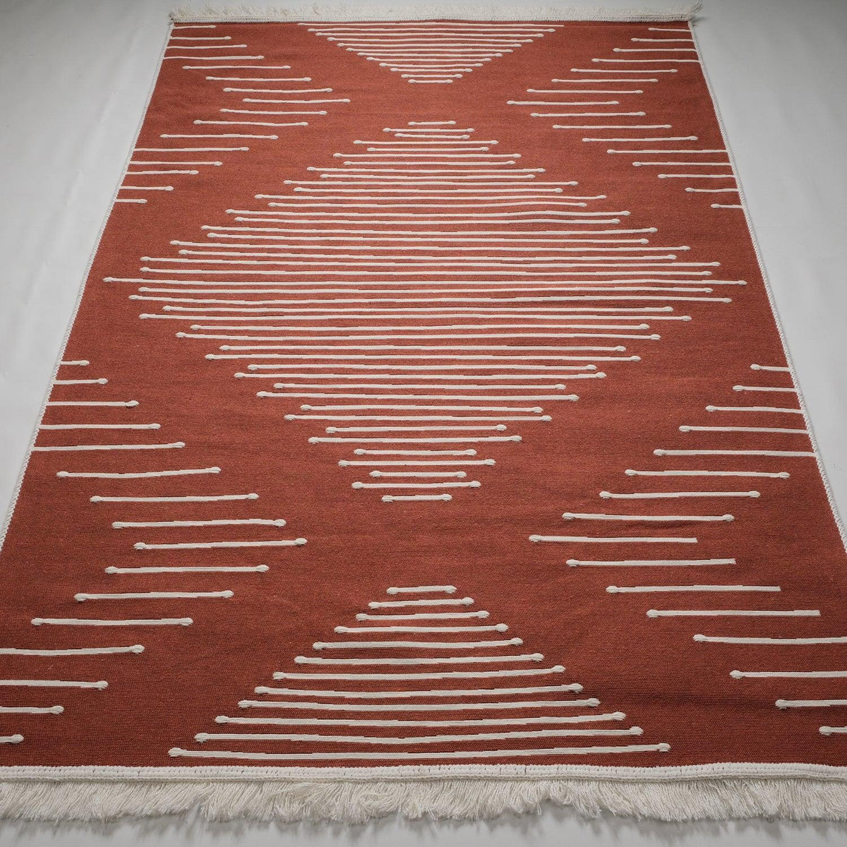 Kehribar serisi geometrik terra kilim — terra zeminde krem çizgi üçgenler, tamamı karşıdan
