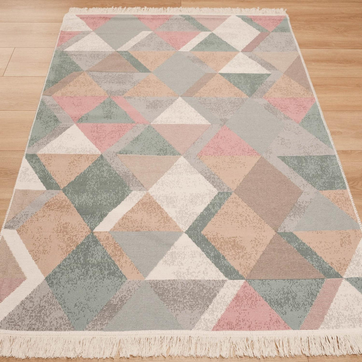Kehribar Series multicolor triangle-pattern kilim — angled full length on parquet, pastel triangles, cream fringe below