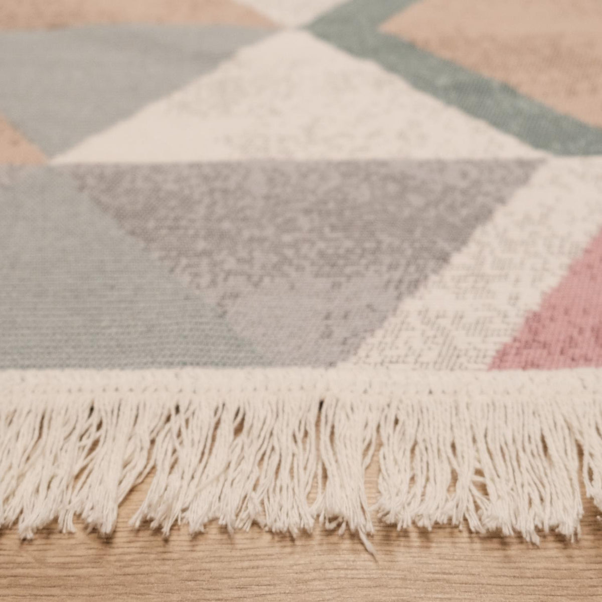 Kehribar Series multicolor triangle-pattern kilim — close view of the fringed edge, powder and gray triangles above