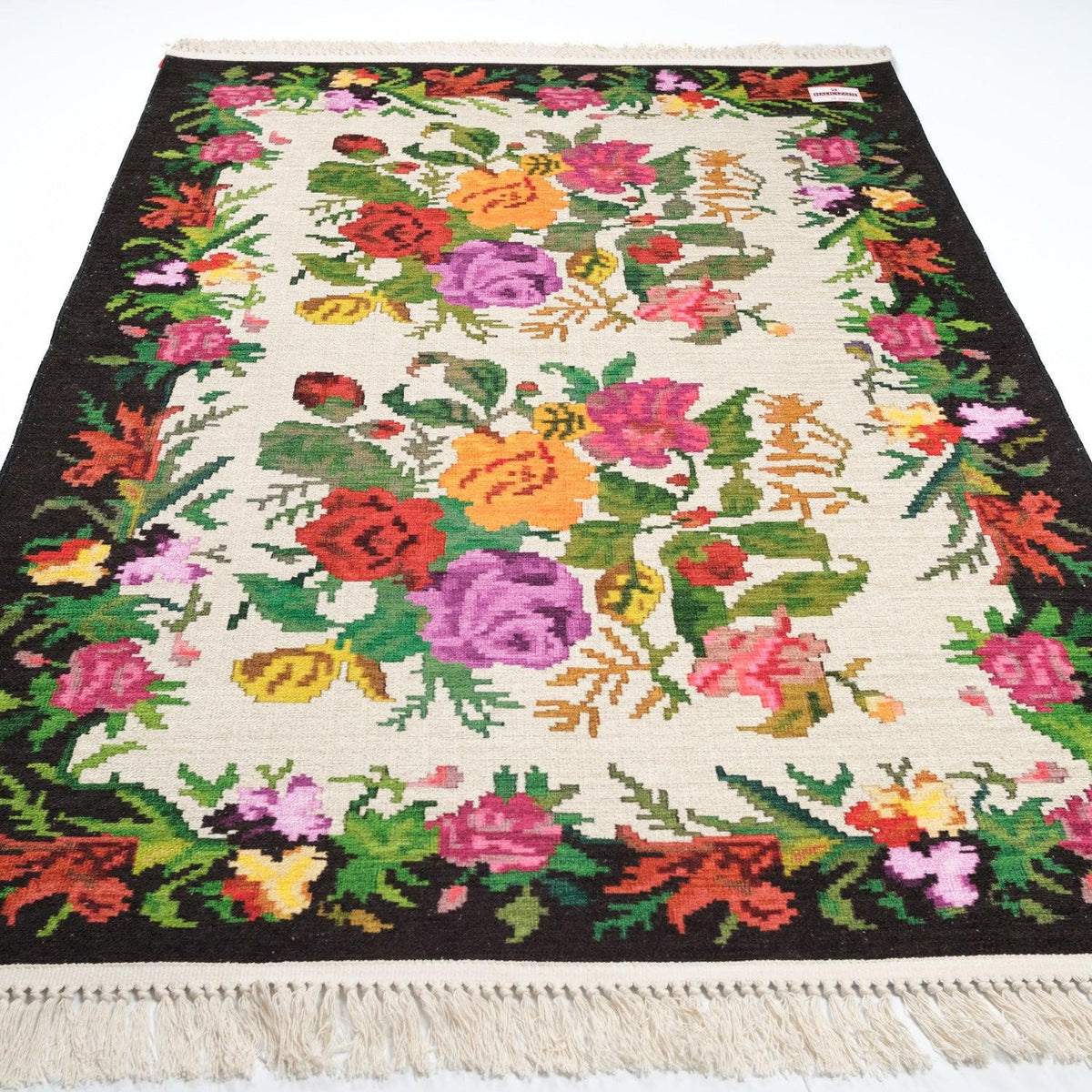 Kehribar Series cream Karabagh-pattern rug — angled full view on white; rose bouquets on cream, dark border