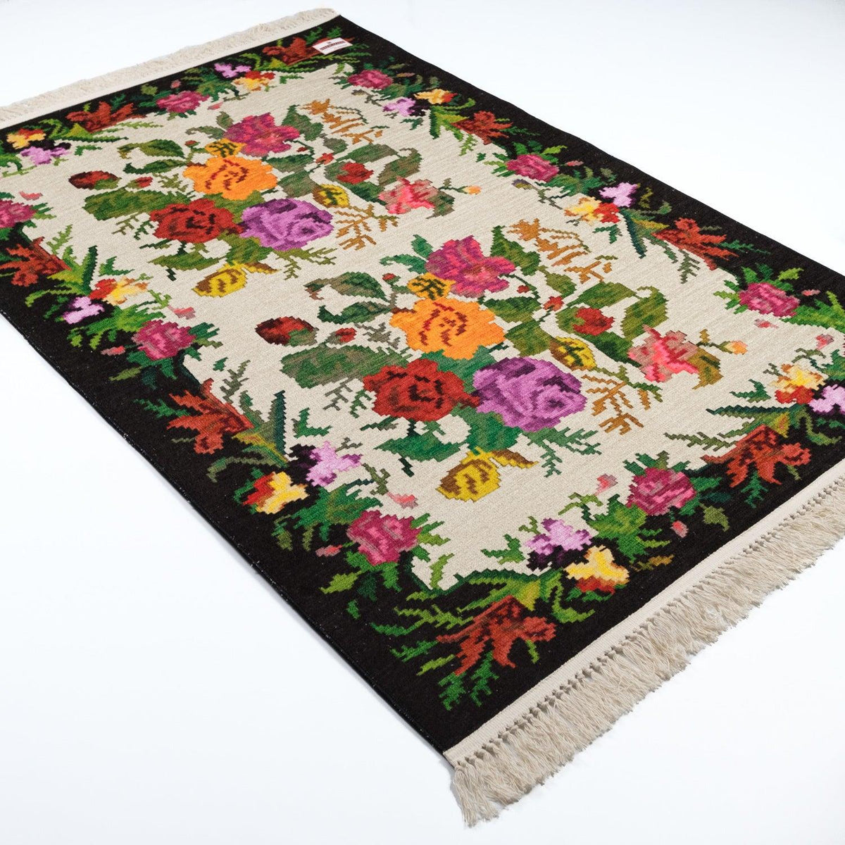 Kehribar Series cream Karabagh-pattern rug — angled from the other end on white; a bunch of cream fringe at the corner