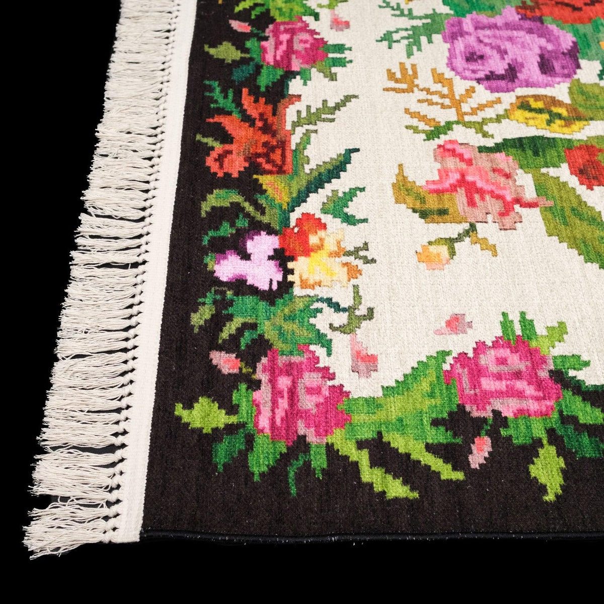Kehribar Series cream Karabagh-pattern rug — edge on black; floral border and the row of cream fringe up close